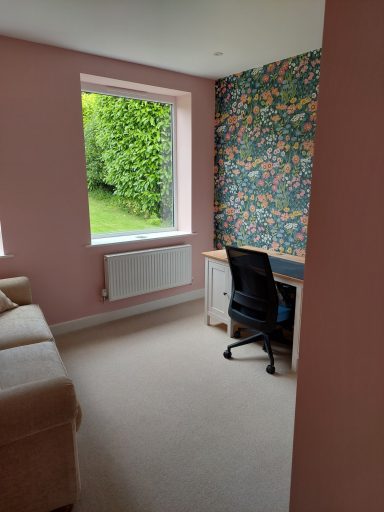 Office with flora wall paper and view to garden