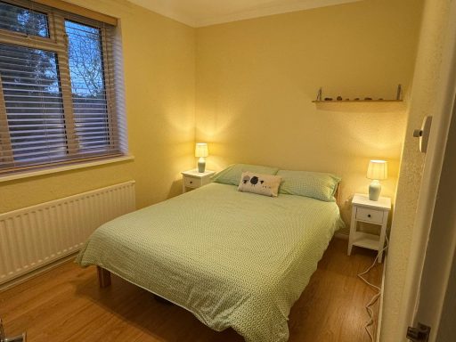 Bedroom with soft yellow walls and lighting with bed in the centre